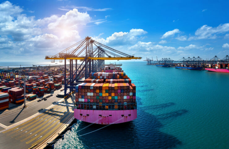 Aerial view of cargo ship and cargo container in harbor.
