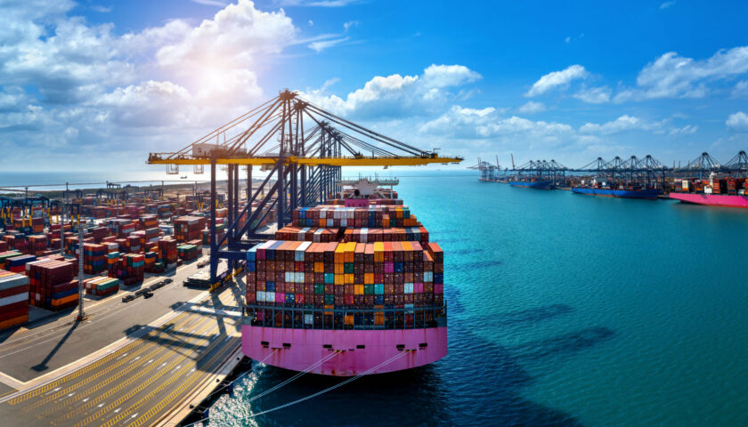 Aerial view of cargo ship and cargo container in harbor.